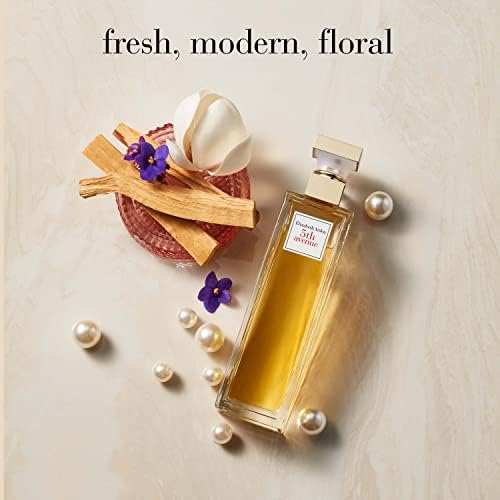 Perfume bottle with wooden accents, purple flowers, and pearls on a marble surface. Text reads fresh, modern, floral.