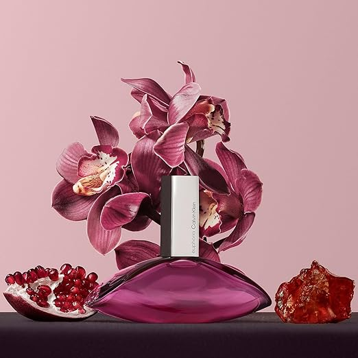 Pink orchid perfume with floral design, flanked by pomegranate and amber on a pink background. Stylish and elegant.